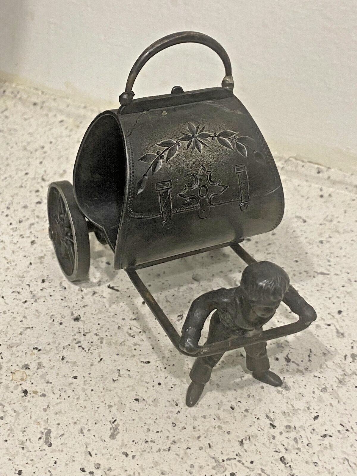 This figural napkin ring is also unmarked but is authentic. It has a boy pulling the ring behind him on a cart.
